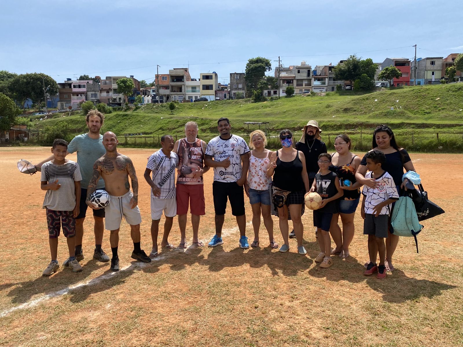 Cast, crew and neighbourhood kids line up on the dirt pitch
