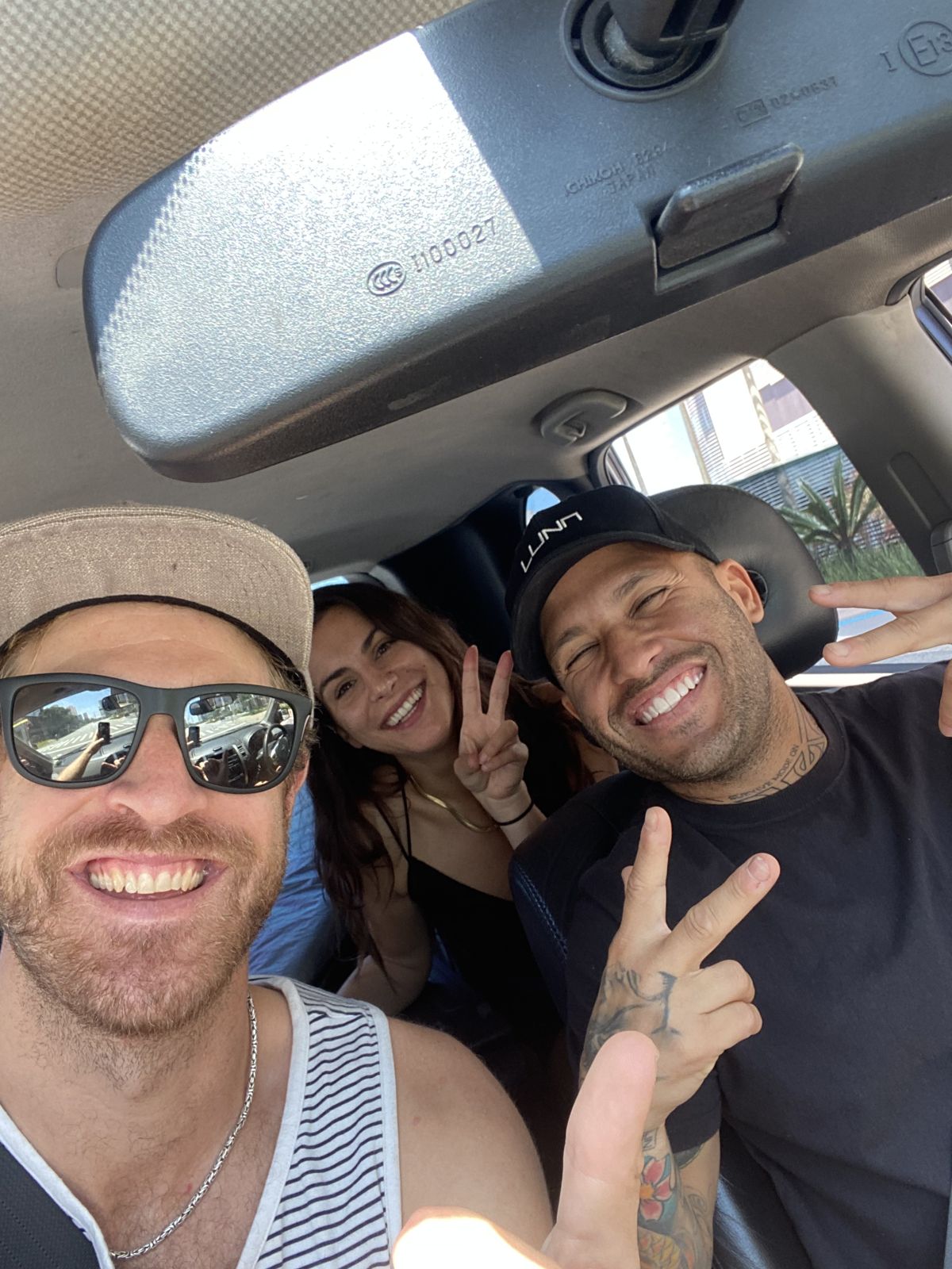 Nick, Marcelo and a crew member grin in a car selfie