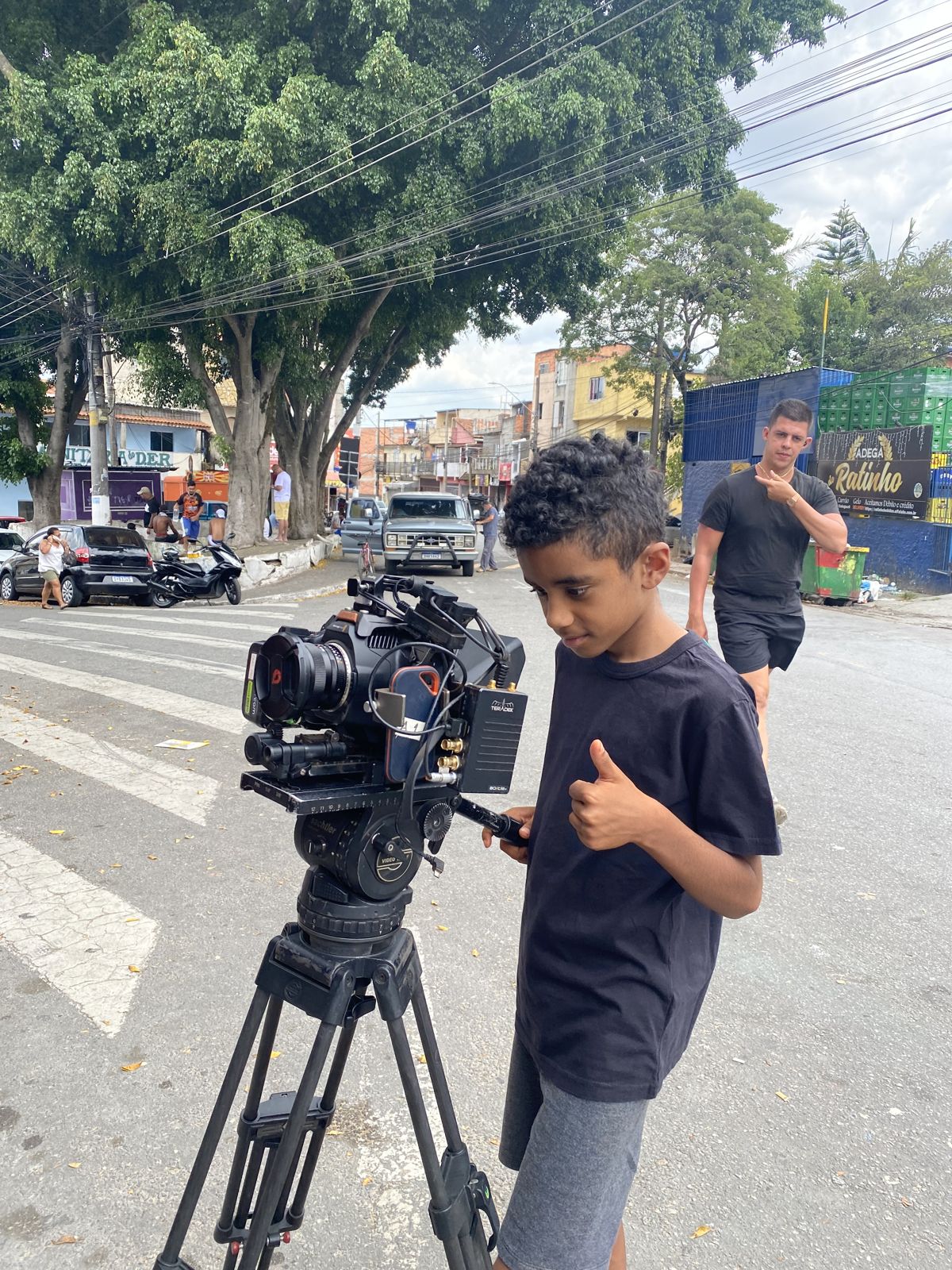 The boy gives a thumbs-up from behind the camera