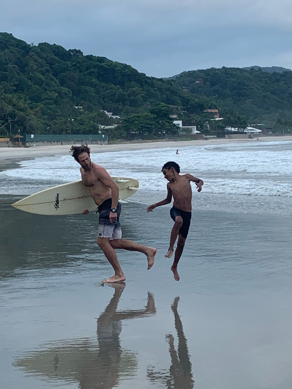 Nick and the boy play-fight at the water’s edge