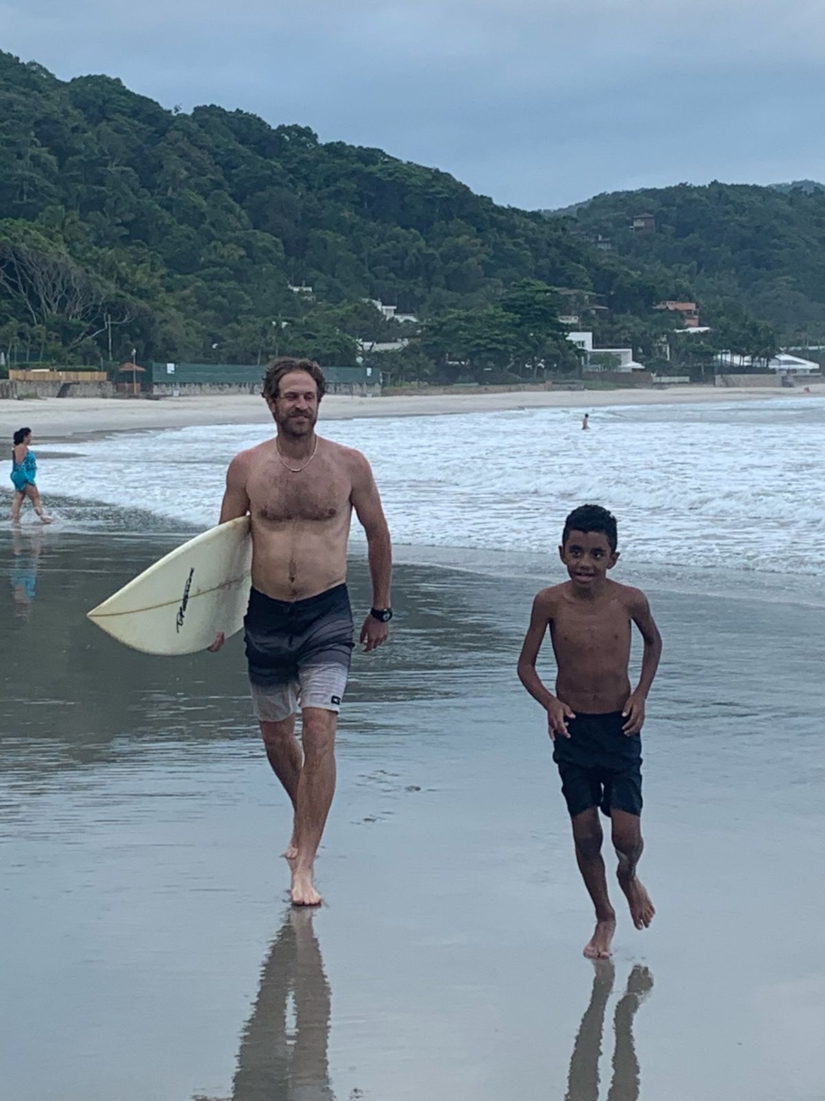 Nick and the boy walk up the beach together