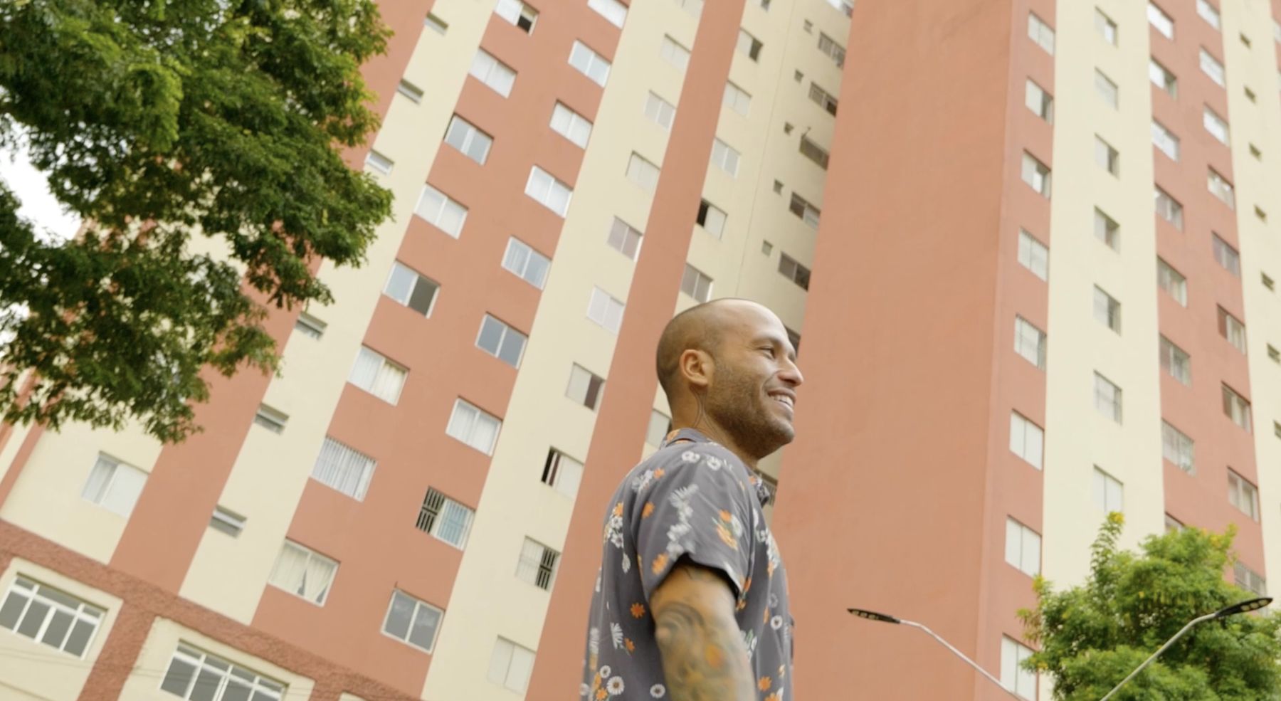 Marcelo smiles beneath a tall apartment tower
