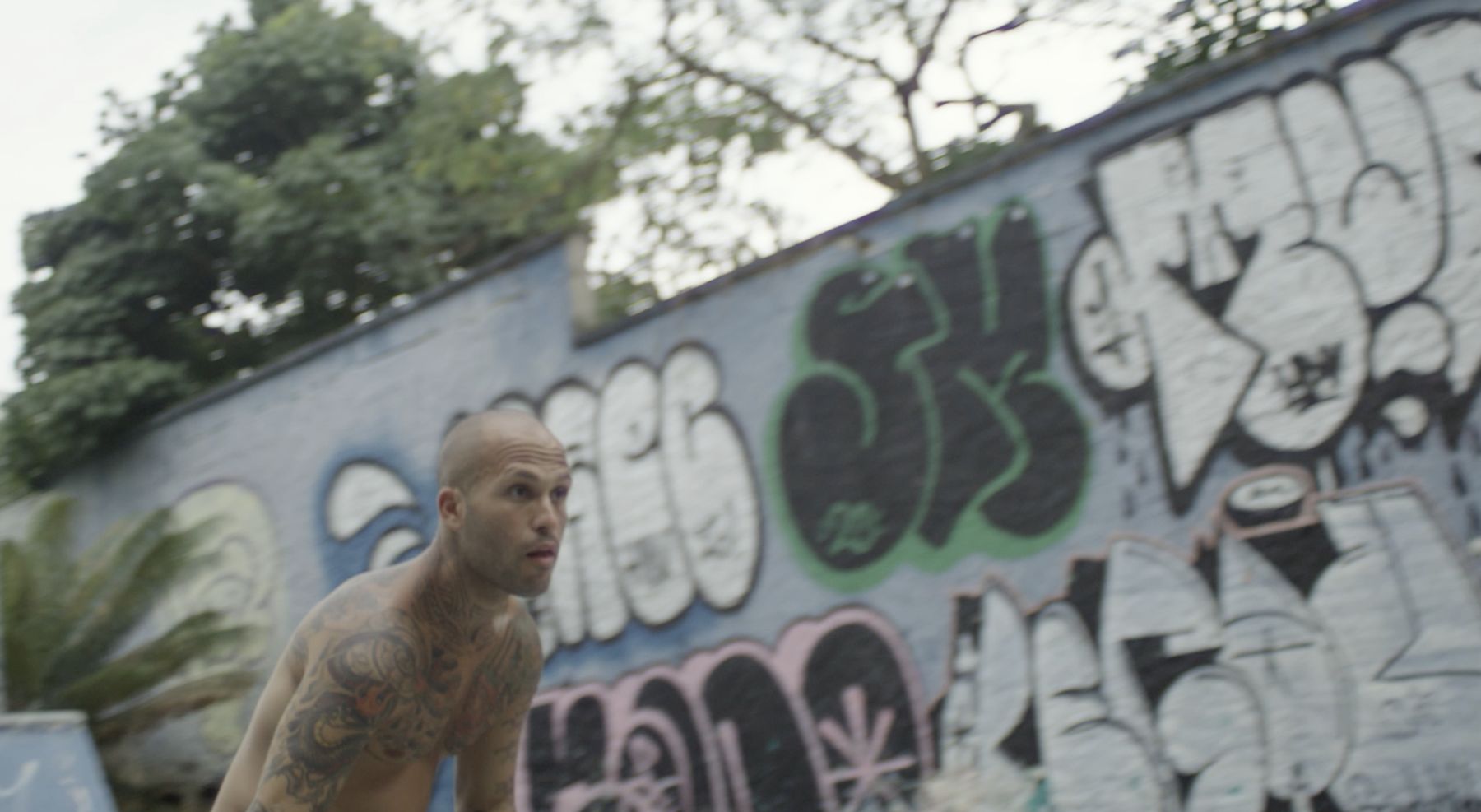 Marcelo skates past a graffiti-covered wall