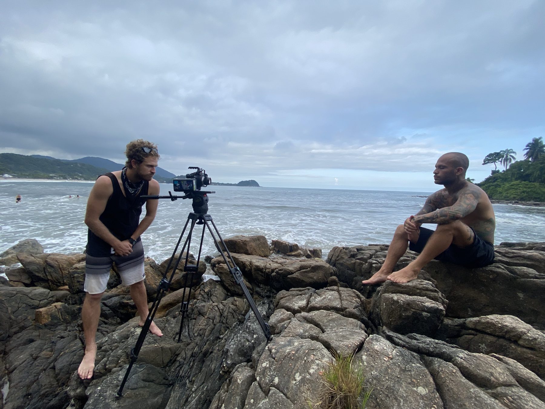 Nick Page frames Marcelo Luna on the rocks above the sea for an interview