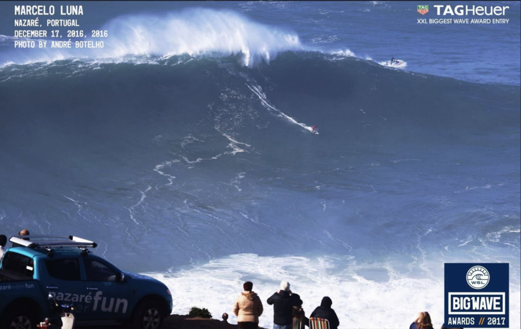 Marcelo Luna rides a giant wave at Nazaré as spectators watch from the cliff