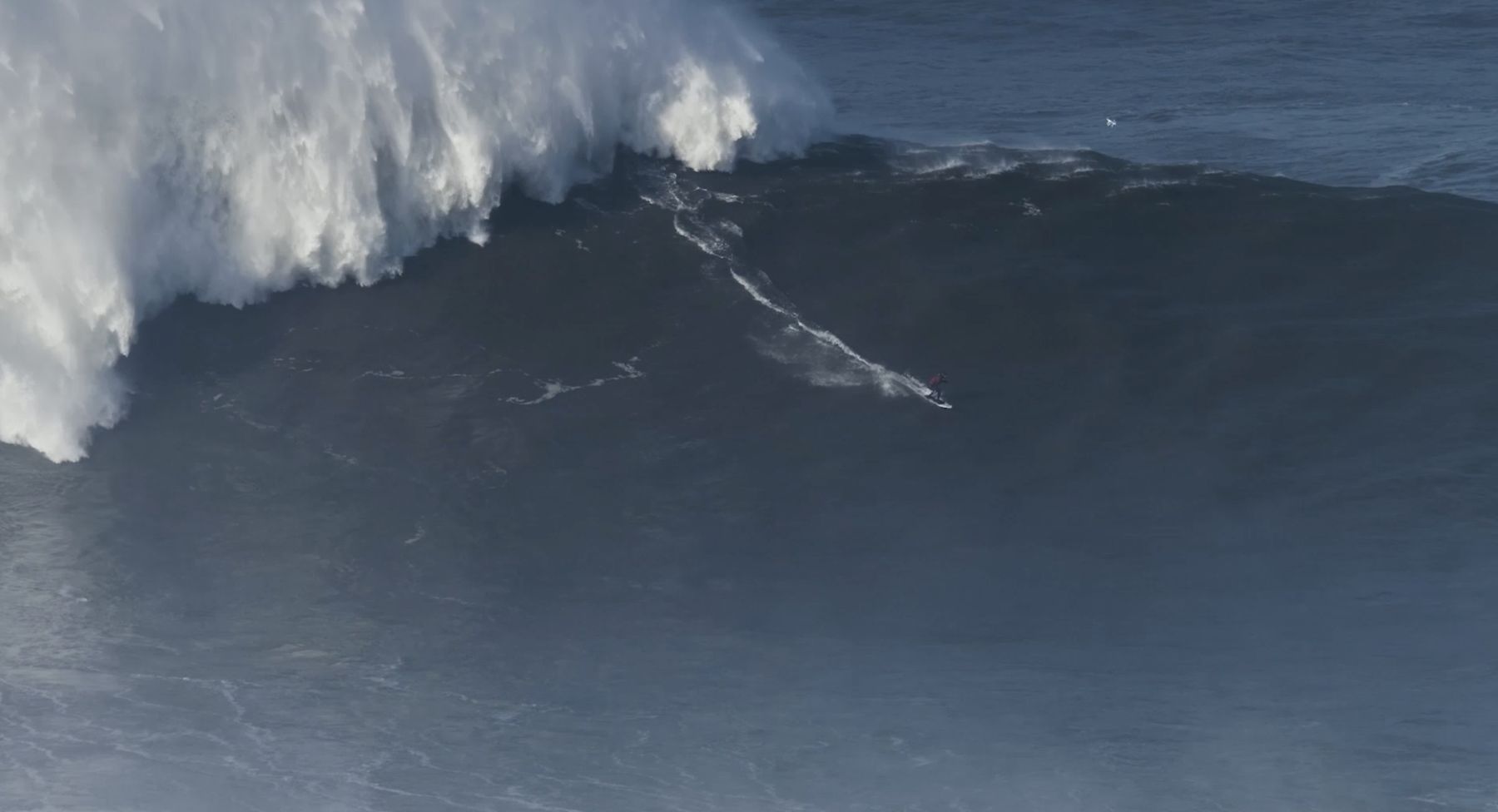 Marcelo drops down the dark face of an enormous wave