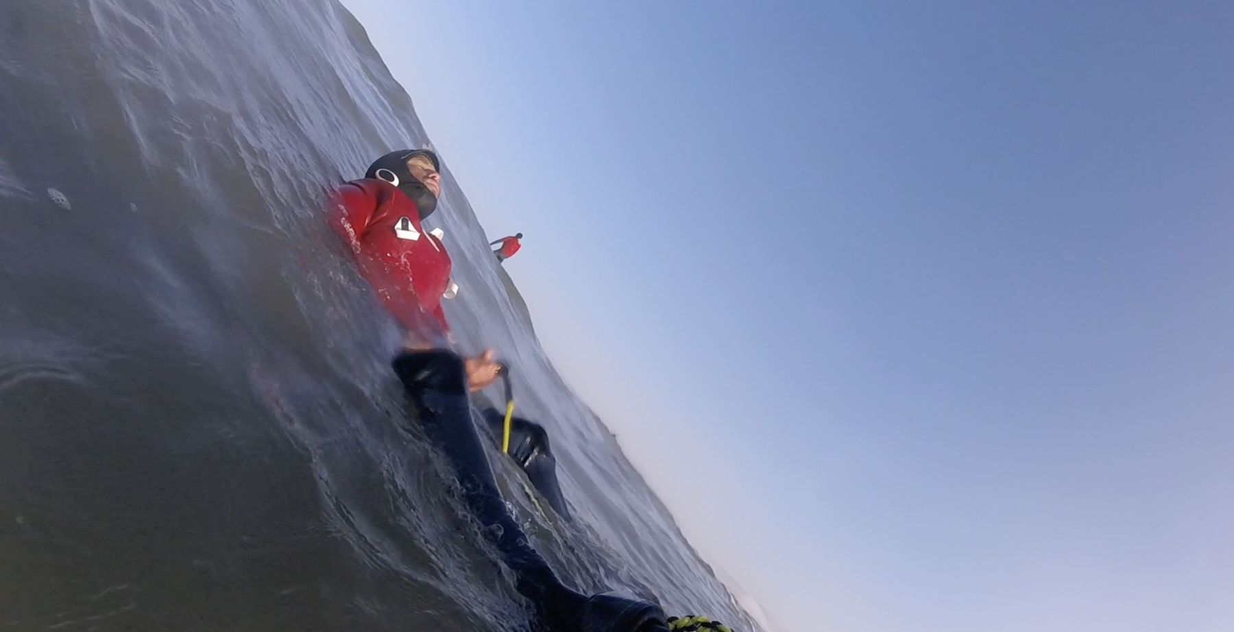 Point-of-view: the camera tilts as Marcelo is towed up a wave face