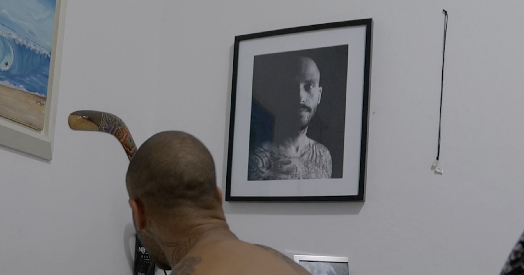 Marcelo looks up at a framed black-and-white portrait of himself